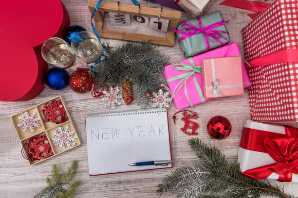 istock Top view at wooden table with Christmas decorations and notepad with 'New Year' word 1278113696
