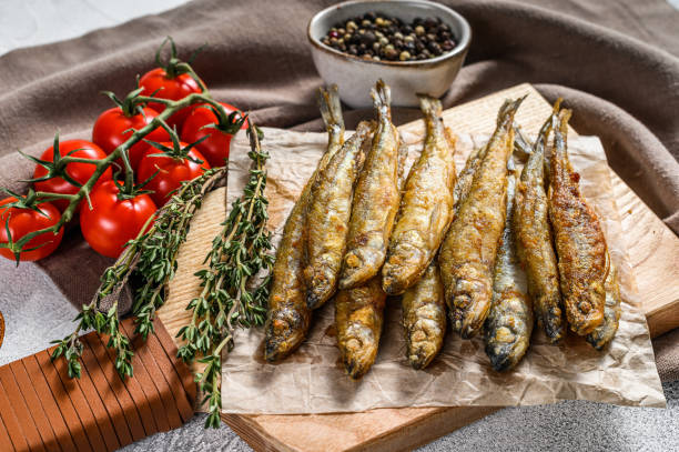 istock Fried smelt, sprats. Small fried fish. Gray background. Top view 1278113980