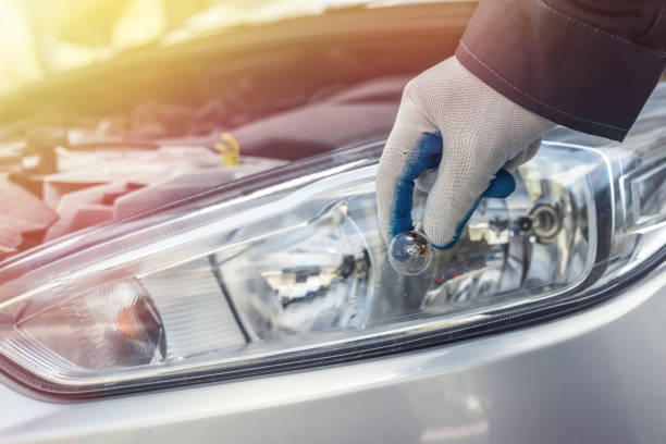 istock Male's hand holding new halogen car light bulb, mechanic servicing light 1278114480