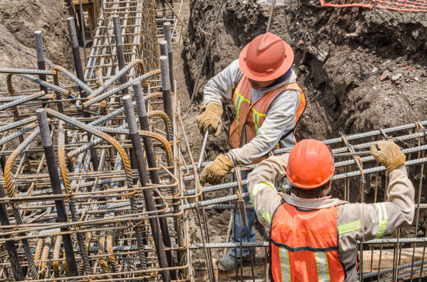 Construction workers laying the foundation with iron rods Huge metal mesh assembled with steel rebar rods as to be used as columns in construction grill rods stock pictures, royalty-free photos & images