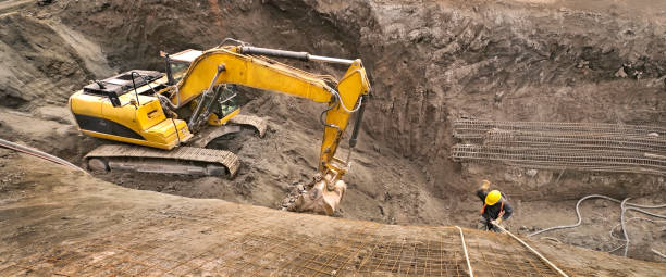 panoramablick auf ein baggerfahrzeug auf der baustelle unter einem abseilarbeiter. - wire mesh equipment gear working stock-fotos und bilder