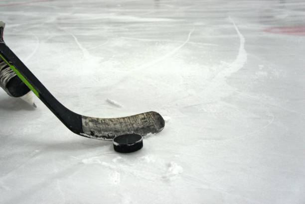 istock hockey stick with puck 1278118239