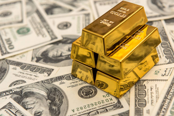 istock gold bars on the 100 dollar USD banknote as background 1278119108