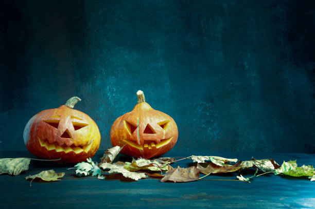 istock Halloween. Image featuring two pumpkins with burning candles and lightning 1278119659