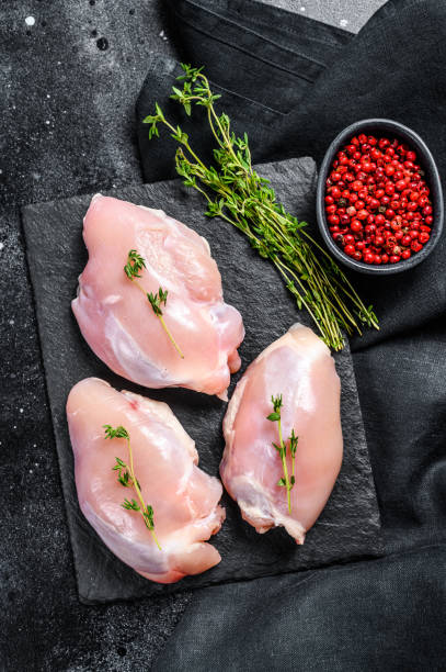 istock Chicken thigh fillet without skin. Black background. Top view 1278122442