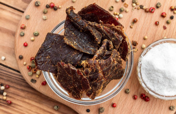 istock Bowl with beef jerky and spices on wooden background. 1278122999