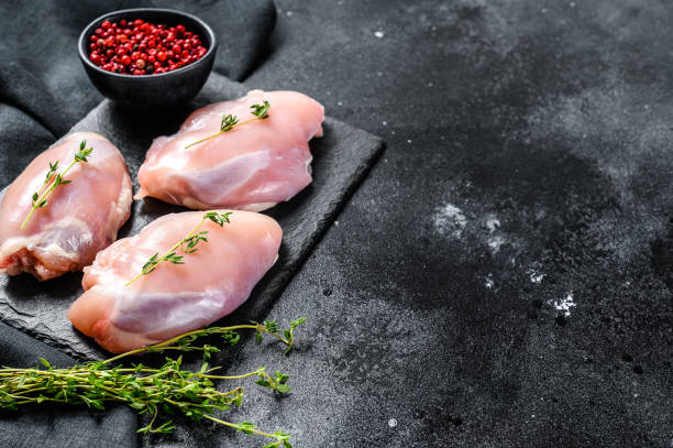 istock Chicken thigh fillet without skin. Black background. Top view. Copy space 1278123246
