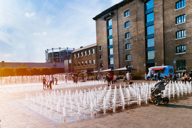 Water fountain Granary Square King's Cross London, UK, July 12, 2019: Granary Square People enjoy  outdoor, water fountain granary stock pictures, royalty-free photos & images