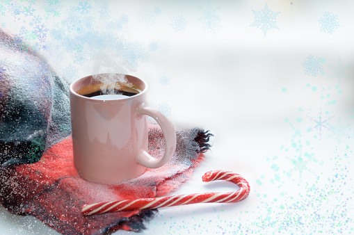 A mug of hot coffee is on the windowsill. Nearby lies an angry blue scarf and lollipop candy