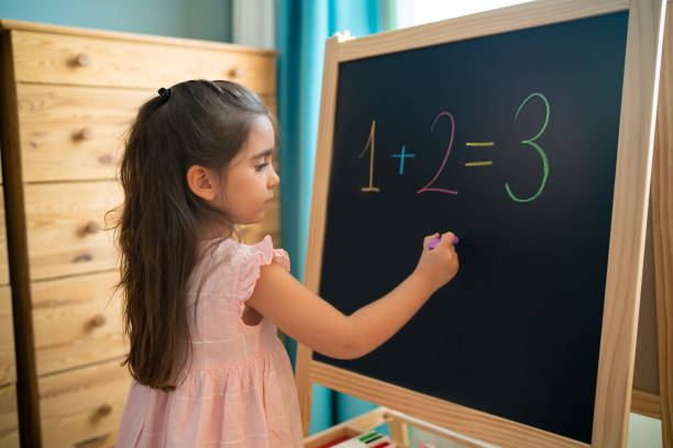 istock Little girl writes on blackboard 1278129696