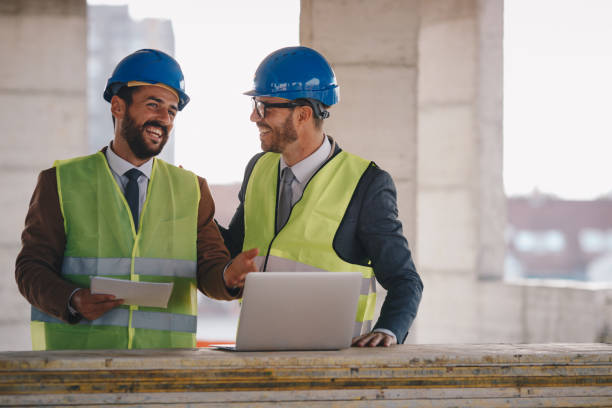 istock Two young adult workers with hard helmets on their head. 1278132260