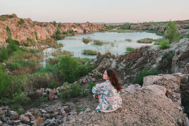 istock Woman looking at scenic lake at sunset 1278133300