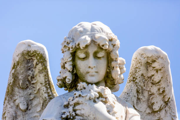 istock Angel, old statue of angle with flowers, blue sky background with copy space 1278134983