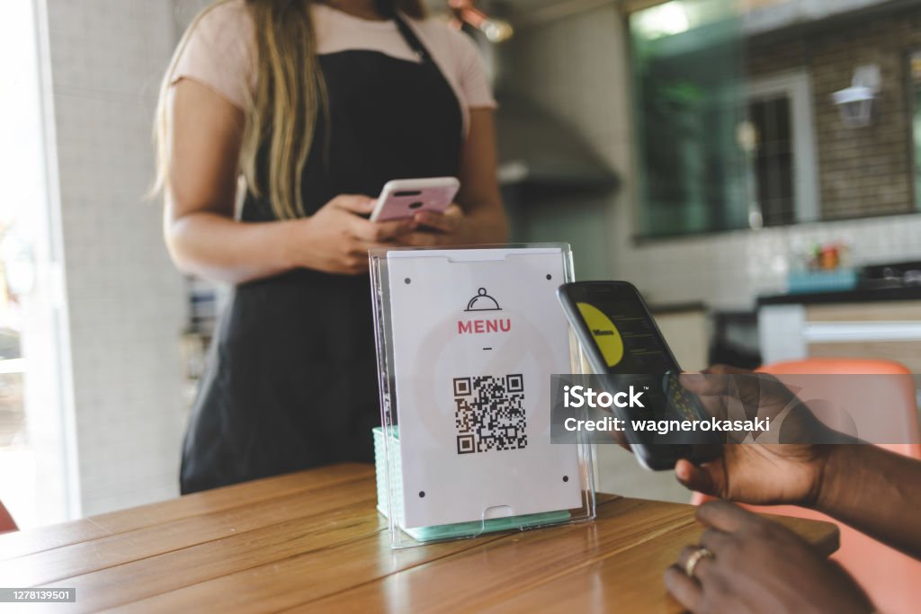 Customer scanning QR code to view food menu online QR Code Stock Photo