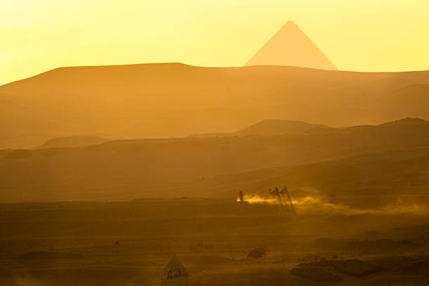 Those traveling by camel and Pyramids in Giza, Egypt.