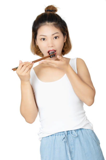 Chinese woman holding sushi with chopsticks isolated on white background