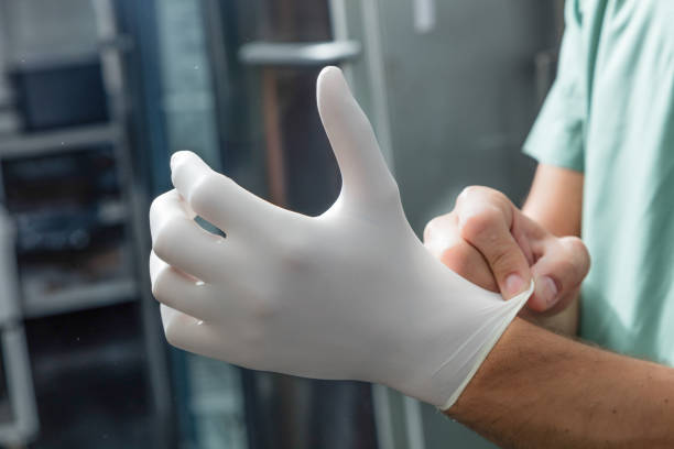 A gloved hand shows five fingers. Isolated on a white background. Close-up.