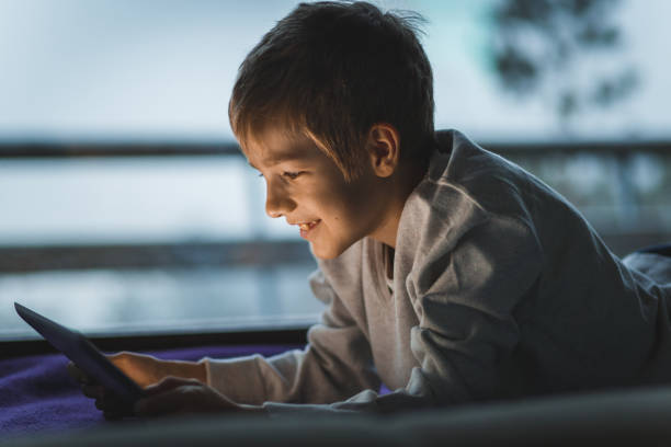 istock Boy having fun while watching cartoons on his digital tablet and relaxing 1278156910