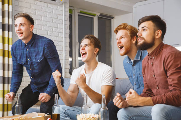 istock Men watching sport on tv together at home team won 1278157277