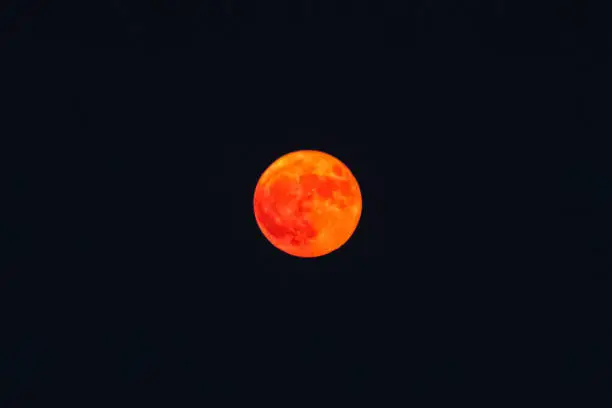 Photo of Orange haze over blurry red full moon, low visibility from wildfires smoke, San Francisco, California, United States