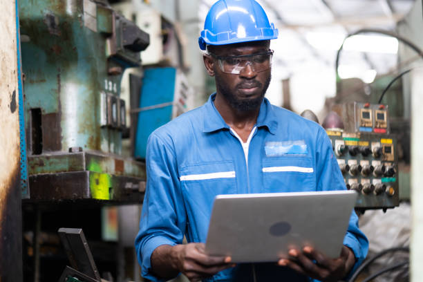 Male Engineer Working on digital tablet in Factory. black male engineer checking Quality control the condition of the machine