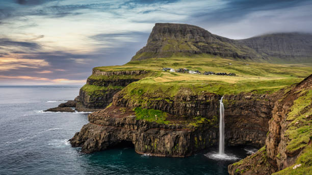 Mulafossur Waterfall Sunset Panorama Gasadalur Vágar Faroe Islands Faroe Islands Sunset Twilight Panorama of the famous iconic natural Mulafossur - Múlafossur Waterfall and Gasadalur village on Vágar Island under colorful vibrant sunset twilight summer sky. Múlafossur Waterfall, Gasadalur, Vagar Island, Faroe Islands, Denmark, Nordic Countries, Europe 1528 stock pictures, royalty-free photos & images