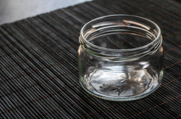 istock Empty glass jar on a dark bamboo napkin. 1278208108