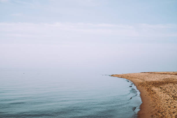 Panoramic view from the sandy Baltic sea shore on a sunny summer day. Azure water and bright cloudy blue sky. Idyllic seascape. Latvia