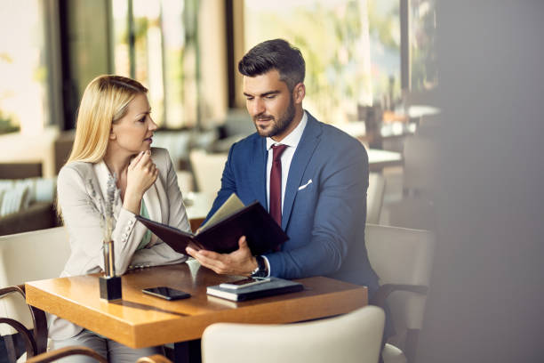 istock Mid adult couple talking while reading a menu in a restaurant. 1278210947