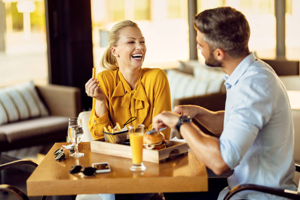 Cheerful couple talking while eating lunch in a restaurant.