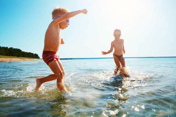 istock Boy and girl playing on the beach 1278211198