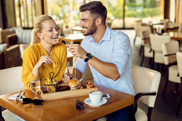 istock Happy man feeding his girlfriend during lunch in a restaurant. 1278211282