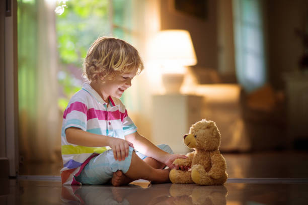 istock Child playing with teddy bear. Kid and toy at home 1278216967