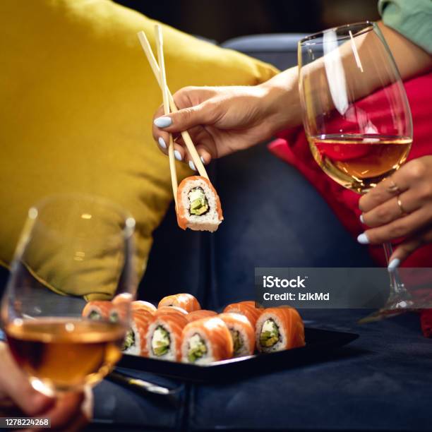 Sushi Roll Philadelphia With Salmon Smoked Eel Avocado Cream Cheese On The Sofa Couple With Glasses Of Wine Japanese Food Stock Photo - Download Image Now