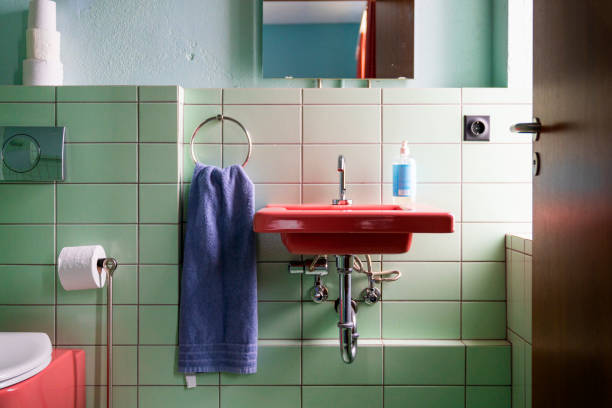 istock Red sink mounted on green tiled wall in bathroom 1278225011