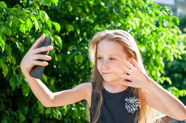 istock Littel girl using mobile phone outdoors 1278231980