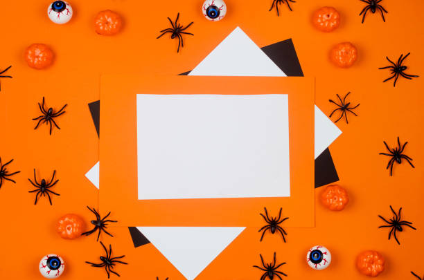 istock Halloween flat lay composition with pumpkins, drink straws, spiders, confetti, treat. 1278232995