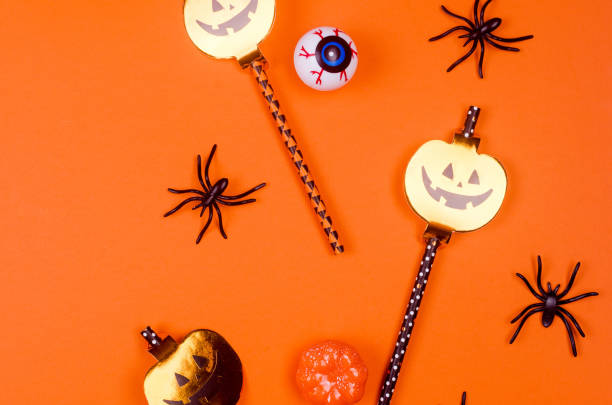 istock Halloween flat lay composition with pumpkins, drink straws, spiders, confetti, treat. 1278233019