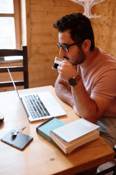 istock Young man working in a cafeteria with laptop and books 1278237015
