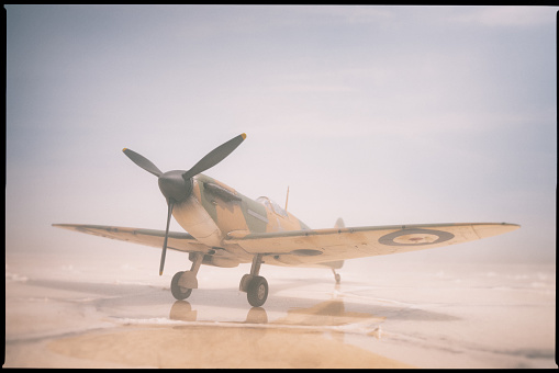 A classic Mk 1 Spitfire sitting on saltflats, with hot sun beating down on it. Model photography.