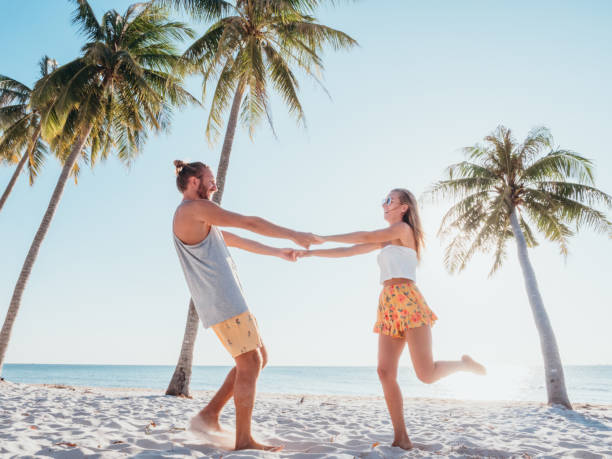 istock Couple holding hands on tropical beach playing 1278244292