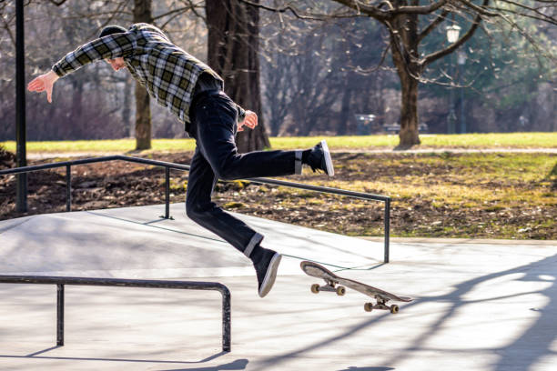 skateboarder cade dal suo skateboard nello skatepark - skateboard park extreme sports recreational pursuit skateboarding foto e immagini stock