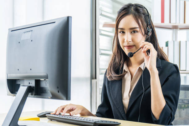 istock Smiling friendly asian female call-center agent with headset working on support hotline in the office 1278247523