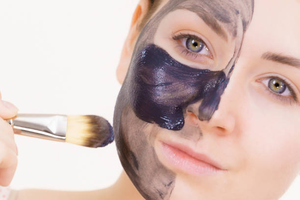 istock Female applying black mud facial mask 1278248769