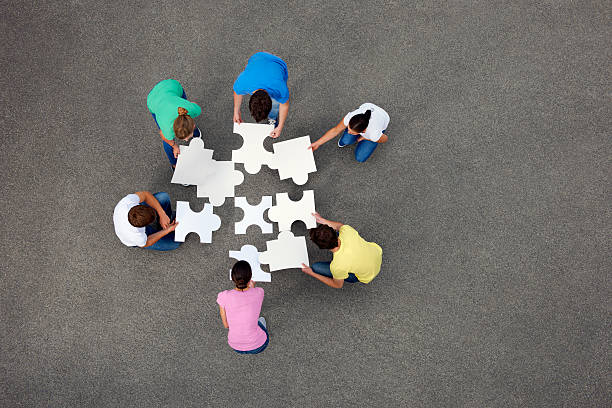 People putting together jigsaw puzzle group of objects stock pictures, royalty-free photos & images