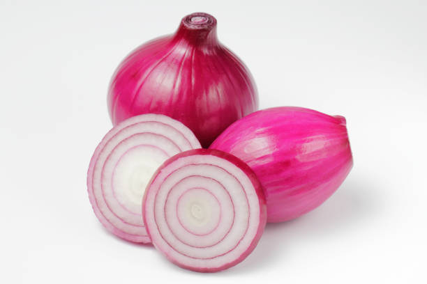 istock Red onion bulbs and chopped onion rings on a white background. 1278251145