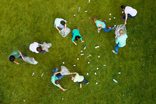 persone pulizia di rifiuti in erba - trash day foto e immagini stock