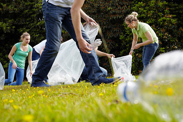 человек очистки мусора на траве - социальный сбор стоковые фото и изображения