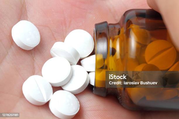 Pills Poured Into A Palm From A Bottle Of Dark Glass Closeup Stock Photo - Download Image Now