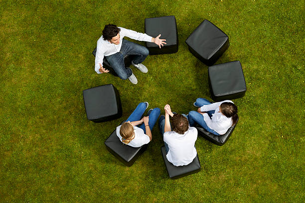 People talking in circle in grass  medium group of objects stock pictures, royalty-free photos & images